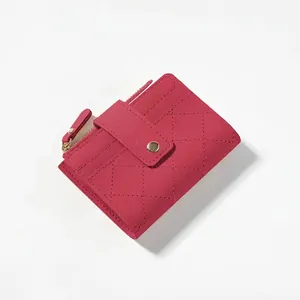 Macro detail of rose red quilted leather wallet with gold zipper and snap closure