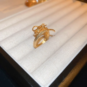 Macro view of gold-plated dragon ring showing intricate scale textures and dragon head