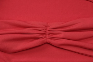 Makroaufnahme der roten Raffung des Stoffes mit feinen Nähten für das Damen-Top