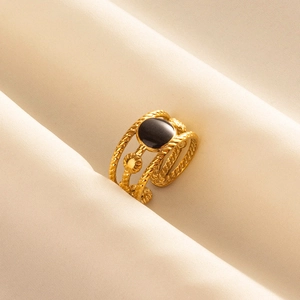 Golden heart-shaped cut-out open ring with black oval gemstone and rope twist band