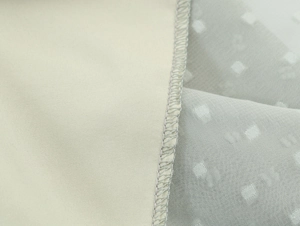 Détail du tissu tissé beige et mousseline à pois gris clair avec coutures de haute précision