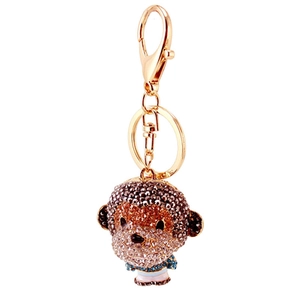 Golden monkey keychain with sparkling rhinestones and colorful enamel on white background
