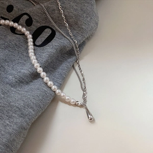 Macro shot of a 925 sterling silver pearl necklace with a polished teardrop pendant detail