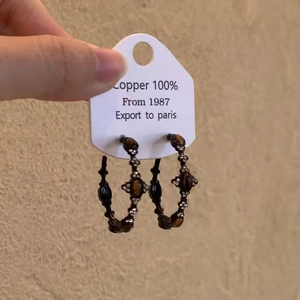 Détails de boucles d'oreilles en cuivre avec pierre oeil de tigre et zircon rétro