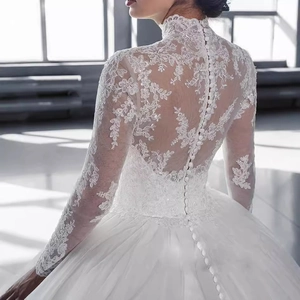 Robe de mariée élégante en dentelle blanche avec col montant et dos boutonné sophistiqué