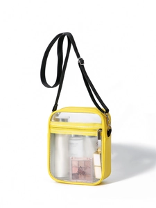 Macro shot of yellow transparent PVC crossbody bag with front zipper and items inside