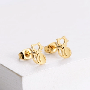 Polished gold cat-shaped stud earrings for women on a clean white textured surface