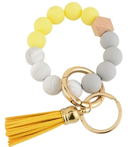 Detail of beaded keychain bracelet with yellow tassel, silicone beads and wooden hexagon