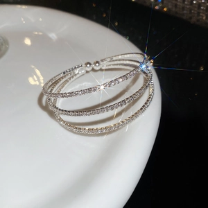Vue macro d'un bracelet triple épaisseur argenté orné de strass étincelants