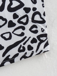 Close-up van zwart-witte dierenprint stof met een soepele witte ritssluiting erop