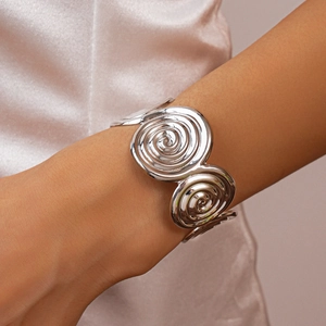 Detail shot of a silver spiral textured wide cuff bracelet showing a metallic finish