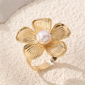 Macro detail of golden flower ring with striped petals, white pearl center, and open band
