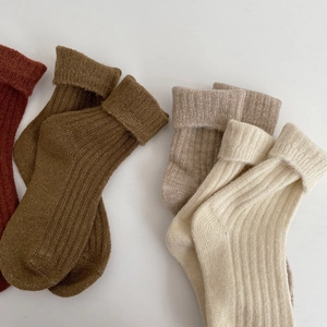 Close-up of thick ribbed wool socks in reddish brown, olive green, and off-white colors