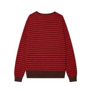 Détail d'un pull en maille rayé rouge et marron avec col rond et poignets côtelés