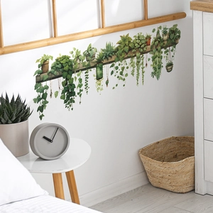 Detail view of green leaf wall stickers with hanging plants on a white wall