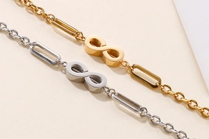 Macro detail of infinity charm bracelets with mixed chain links in gold and silver finish