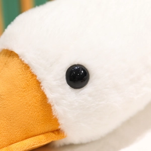 Close-up of plush white goose toy with soft faux fur texture and black beaded eye