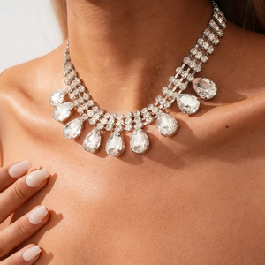 Détail d'un collier à pompon goutte d'eau de luxe avec strass multicouches