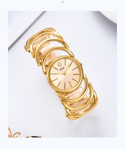 Macro shot of Gedi golden bracelet watch with intricate hollow metal links on white background