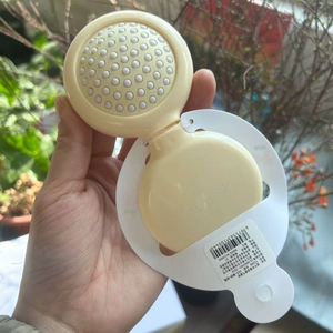 Detail view of a compact yellow folding hairbrush with integrated mirror and massage bristles