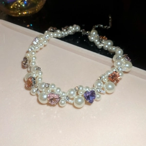 Detail of irregular pearl necklace with heart crystals and sparkling rhinestones