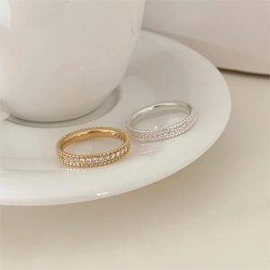 Detail of gold and silver eternity rings with milgrain edges and micro-pave zircons