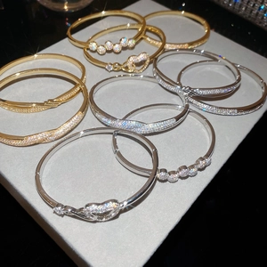 Gros plan de bracelets plaqués or 18 carats et argent avec zircons et fermoir charnière
