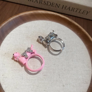 Detail of cartoon poodle rings with zircon bows and pearls on a wooden display
