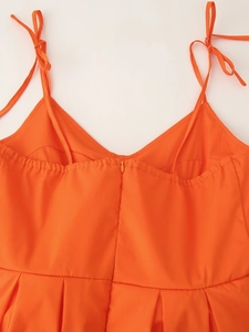 Detail van oranje bandjesjurk met onzichtbare rits achter en strikbandjes op de schouder