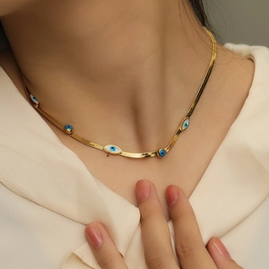 Gold plated titanium steel snake chain necklace with blue and white evil eye charm on model