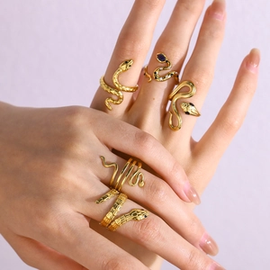Detail showing stacked 18K gold plated snake rings with blue zircon inlay on hand