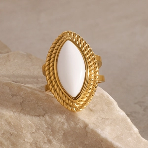 Detailed close-up of 18k gold ring featuring white marquise stone and vintage rope texture