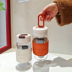 Minimalist glass tumbler with tea infuser and leather insulation sleeve in dual colors