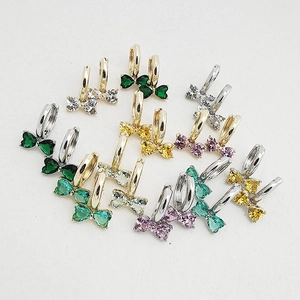 Close-up of bow-shaped crystal earrings in various colors with heart-cut gemstones
