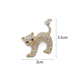 Golden cat brooch with sparkling white crystals and black stone eyes, 3.5cm x 3cm size