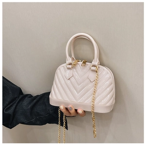 Detail of light pink jelly shell bag with gold chain strap and textured PVC finish
