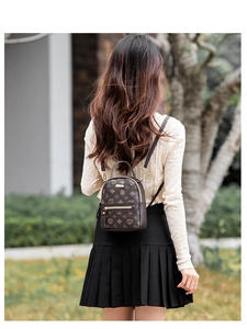 Close-up of a dark brown floral patterned mini backpack worn by a model in outdoor setting