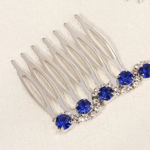 Macro view of silver bridal hair comb with dark blue gems and clear crystals