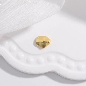 Minimalist gold S925 sterling silver faceted irregular pebble bead on white ceramic tray