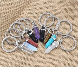 Macro detail of various colorful hexagonal crystal pendants on natural linen texture