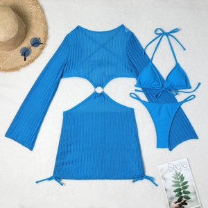 Flat lay of blue hollow-out knit beach cover-up with metal ring and bikini set