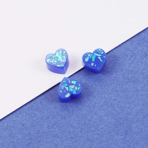 Three blue heart-shaped resin opal stones with sparkling glitter flakes on split background