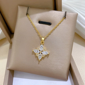 Detail of clover four-pointed star pendant with clear crystals in a luxury gift box