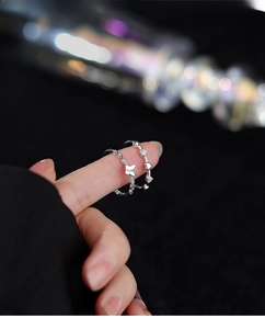 Macro detail of S925 sterling silver heart and butterfly rings with pavé zircon setting