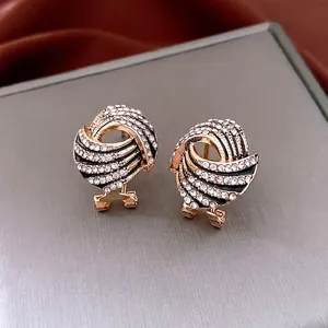 Vintage gold wing-shaped spiral stud earrings with black enamel and sparkling rhinestones