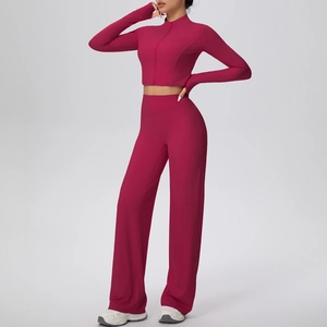 Détail d'un ensemble de yoga rouge baie avec haut zippé et pantalon à jambes larges
