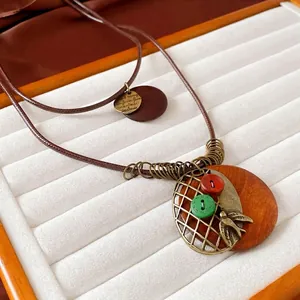 Ethnic geometric long sweater necklace with brown wood pendant and metal bird detail