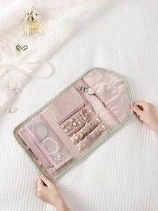 Organizador de joyas de viaje rosa bolsa de almacenamiento plegable con compartimentos.