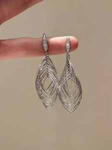 Macro detail of silver oval hollow leaf earrings featuring sparkling zircon stone inlay
