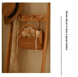 Detail of handmade wicker basket bag featuring a beige drawstring lining and round handles